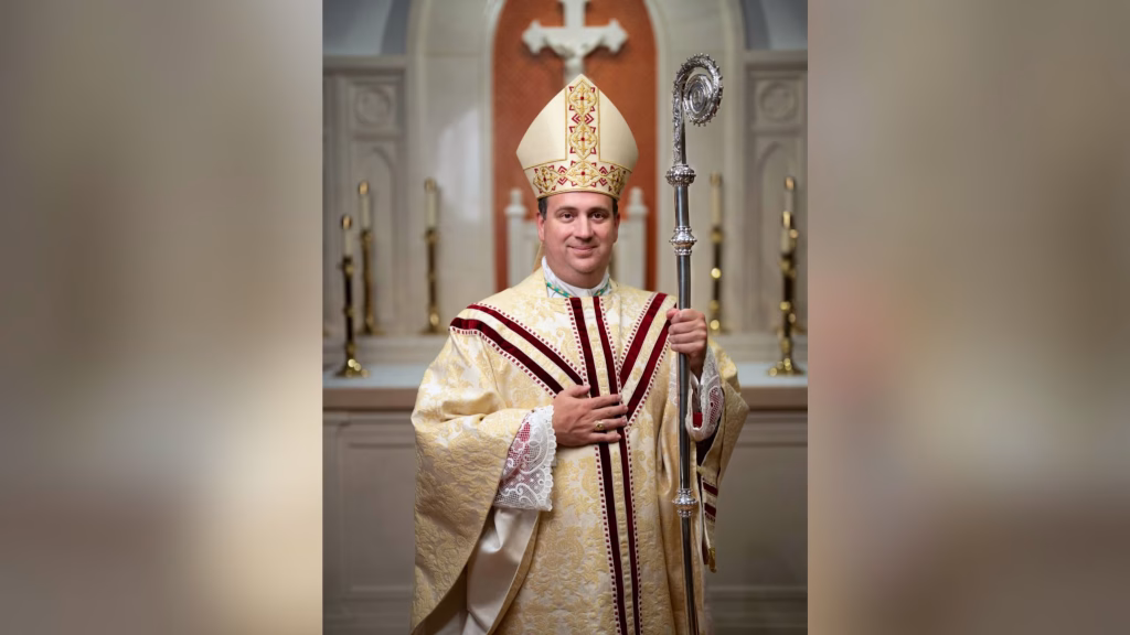 Bishop Lopes smiling with mitre and crosier.