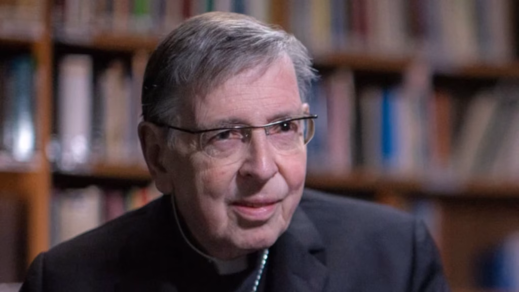 Cardinal Koch with blurry library behind.