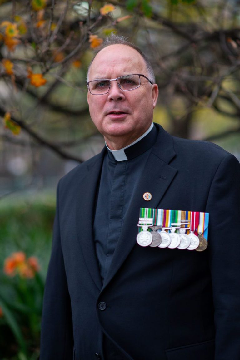 Bishop-elect Stuart Hall recently appointed Bishop for the Military Ordinariate standing wearing medals on his left lapel.